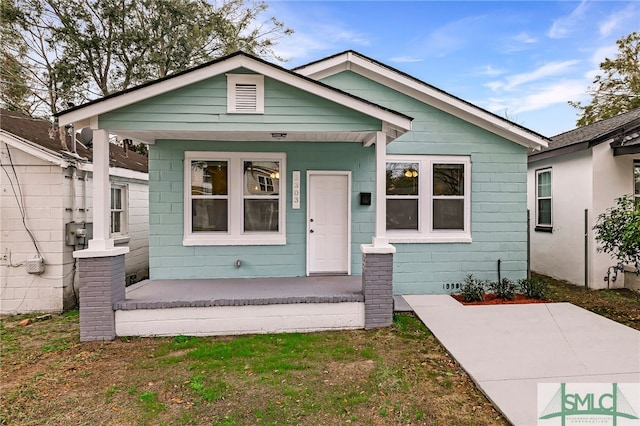 bungalow-style house featuring a porch and a front lawn