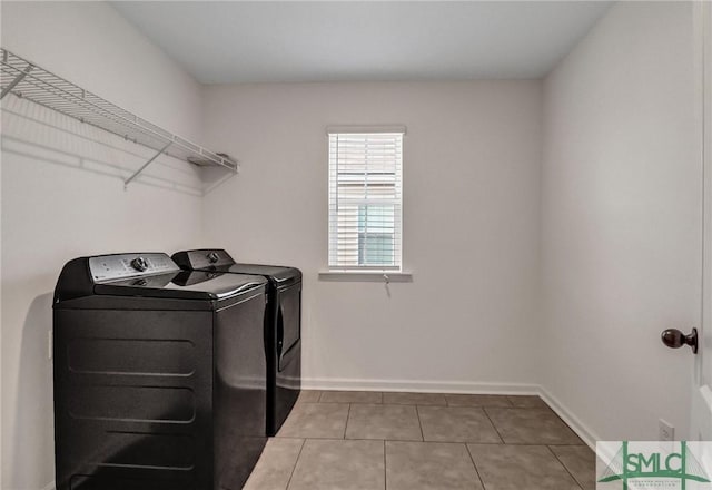 clothes washing area featuring light tile patterned flooring and independent washer and dryer