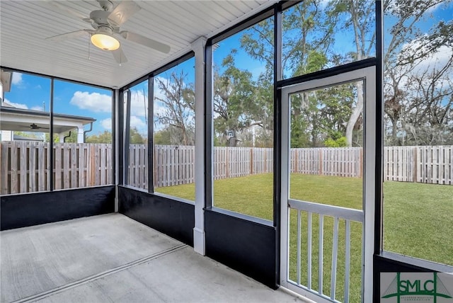 unfurnished sunroom featuring ceiling fan