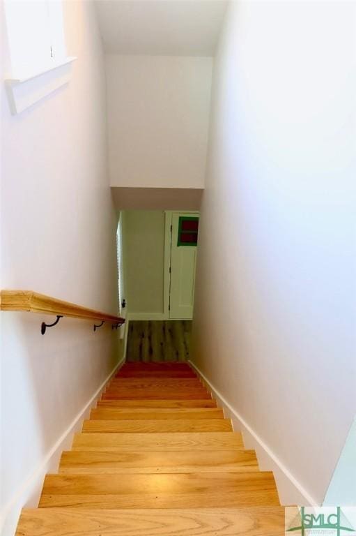 stairway featuring wood finished floors and baseboards