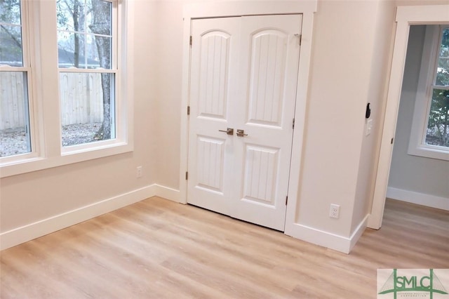 unfurnished bedroom featuring light hardwood / wood-style floors and a closet