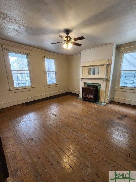 unfurnished living room featuring ornamental molding, hardwood / wood-style floors, and ceiling fan