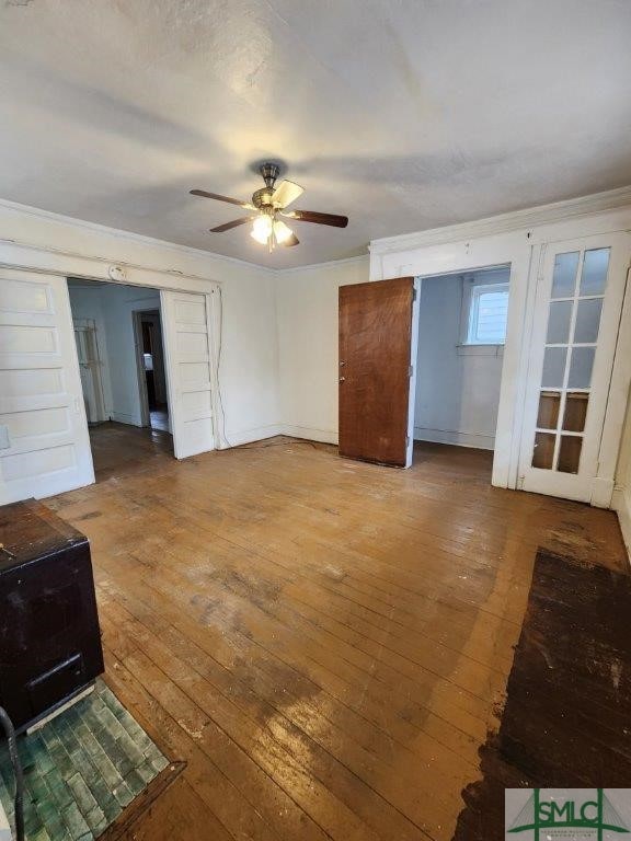 living room with crown molding, wood-type flooring, and ceiling fan