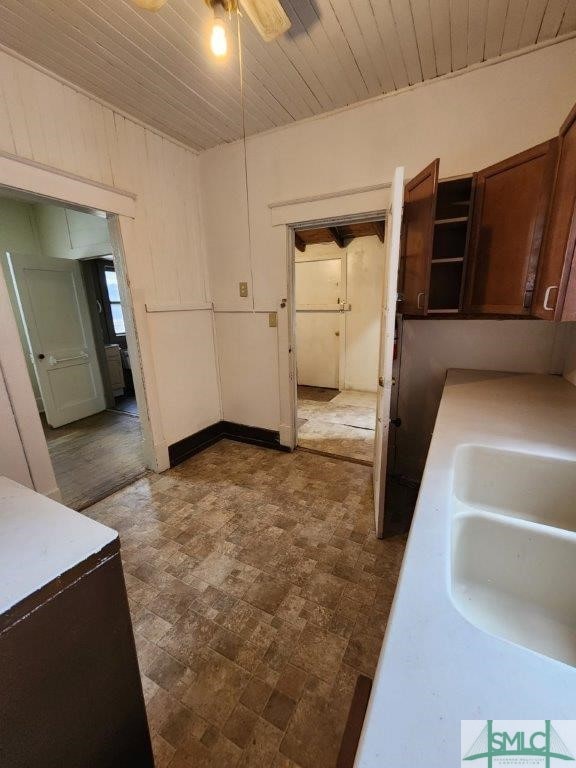 kitchen featuring ceiling fan, sink, and wood ceiling