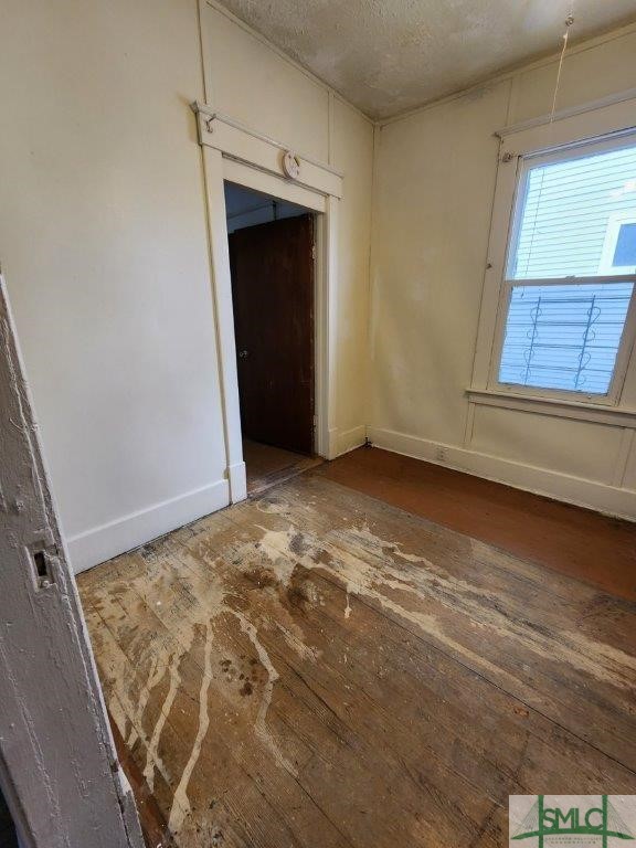 unfurnished room with hardwood / wood-style floors and a textured ceiling