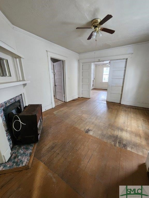 living room with hardwood / wood-style floors, ornamental molding, and ceiling fan