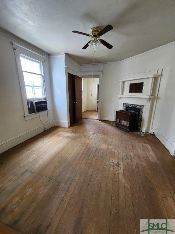 unfurnished living room with hardwood / wood-style flooring, ornamental molding, cooling unit, and ceiling fan