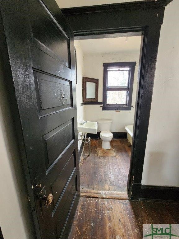 bathroom featuring wood-type flooring and toilet