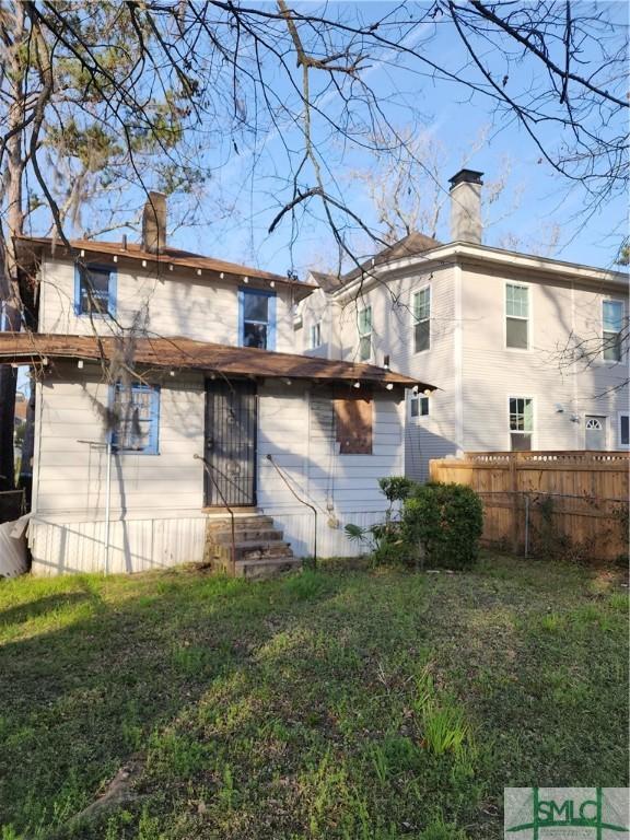 rear view of property featuring a yard