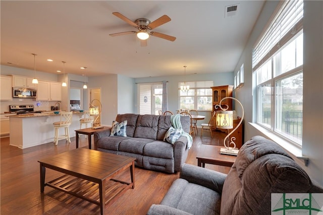 living room with dark hardwood / wood-style floors, sink, and ceiling fan