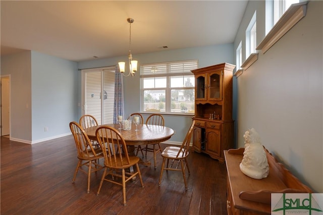 dining area featuring a notable chandelier and dark wood-type flooring