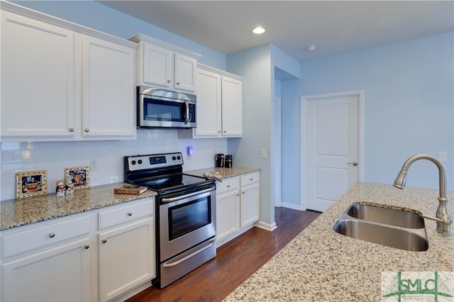 kitchen featuring stainless steel appliances, sink, white cabinets, and light stone counters