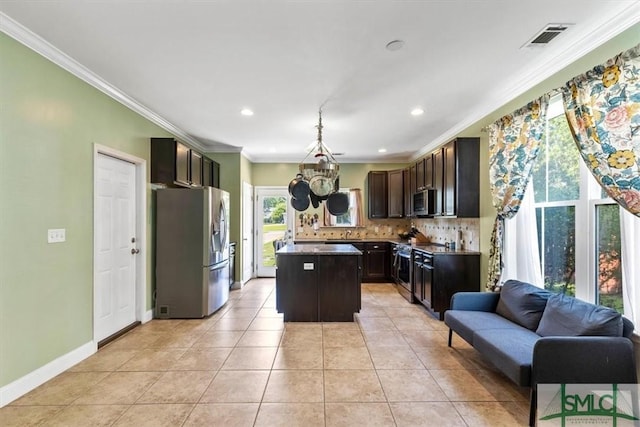 kitchen featuring light tile patterned floors, backsplash, stainless steel appliances, a center island, and ornamental molding