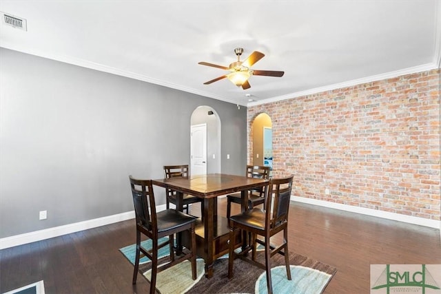 dining space featuring crown molding, ceiling fan, brick wall, and dark hardwood / wood-style flooring