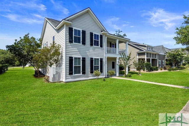 view of front of house with a balcony and a front lawn