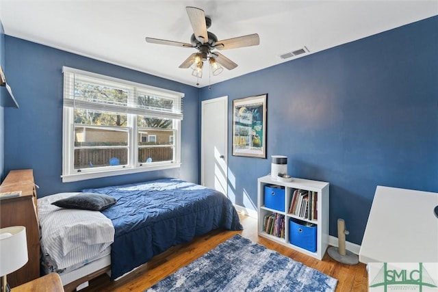 bedroom with dark hardwood / wood-style floors and ceiling fan