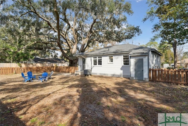 back of property with central AC and a fire pit