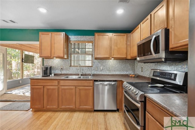 kitchen featuring sink, backsplash, a wealth of natural light, and appliances with stainless steel finishes
