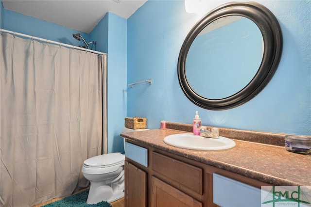 bathroom with vanity, a shower with shower curtain, and toilet