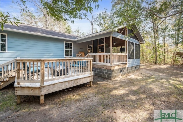 back of property with a deck and a sunroom