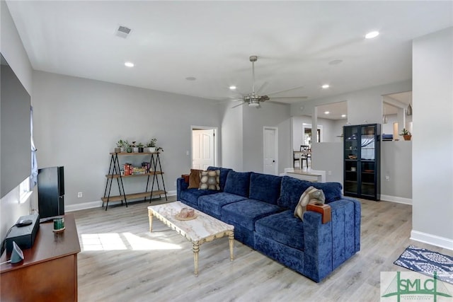 living room with light hardwood / wood-style flooring and ceiling fan