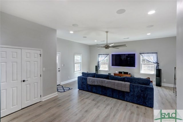 living room featuring ceiling fan, a healthy amount of sunlight, and light wood-type flooring