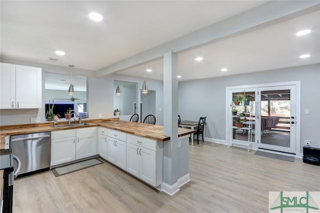 kitchen with hanging light fixtures, dishwasher, wooden counters, and white cabinetry