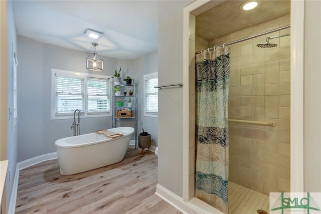 bathroom with hardwood / wood-style floors and separate shower and tub