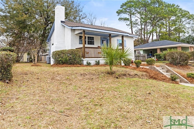 view of front of house featuring a porch, central AC unit, and a front yard