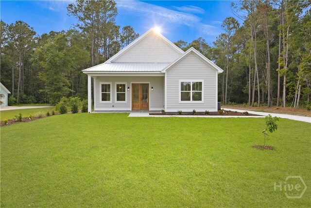 511 Goodman Dr, Midway, GA 31320 - view of front of house featuring french doors and a front lawn