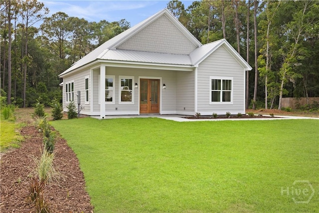 511 Goodman Dr, Midway, GA 31320 - view of front of house featuring french doors, a front lawn, and metal roof