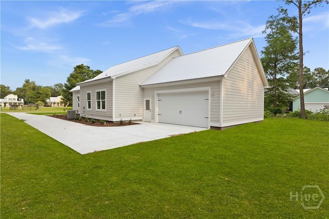 511 Goodman Dr, Midway, GA 31320 - view of side of property featuring central air condition unit, a yard, driveway, a garage, and metal roof