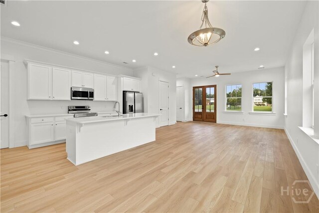 511 Goodman Dr, Midway, GA 31320 - kitchen featuring appliances with stainless steel finishes, a sink, light countertops, white cabinets, and an island with sink