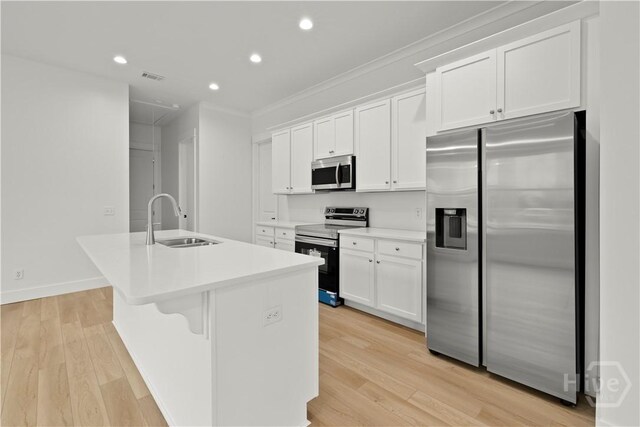 511 Goodman Dr, Midway, GA 31320 - kitchen with appliances with stainless steel finishes, a sink, a center island with sink, crown molding, and white cabinets