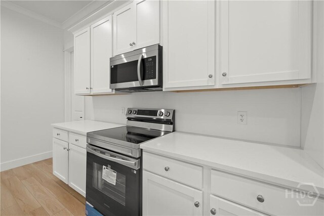 511 Goodman Dr, Midway, GA 31320 - kitchen featuring stainless steel appliances, ornamental molding, light wood-type flooring, white cabinetry, and light countertops