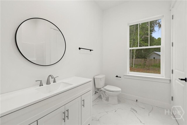 511 Goodman Dr, Midway, GA 31320 - bathroom with marble look tile flooring, vanity, baseboards, and toilet