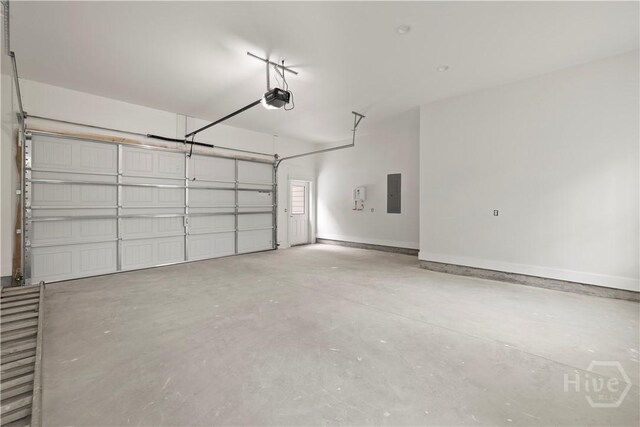511 Goodman Dr, Midway, GA 31320 - garage featuring electric panel, a garage door opener, and baseboards