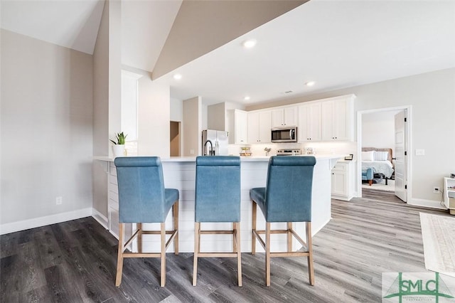 100 Sweetwater Cir, Rincon, GA 31326 - kitchen featuring white cabinetry, appliances with stainless steel finishes, a breakfast bar, and kitchen peninsula