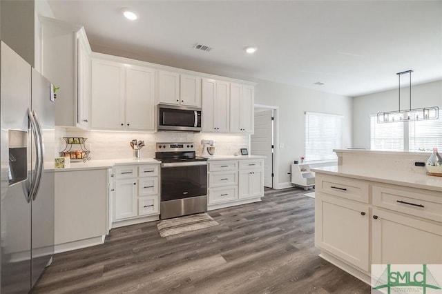 100 Sweetwater Cir, Rincon, GA 31326 - kitchen with dark wood-type flooring, appliances with stainless steel finishes, hanging light fixtures, and white cabinets