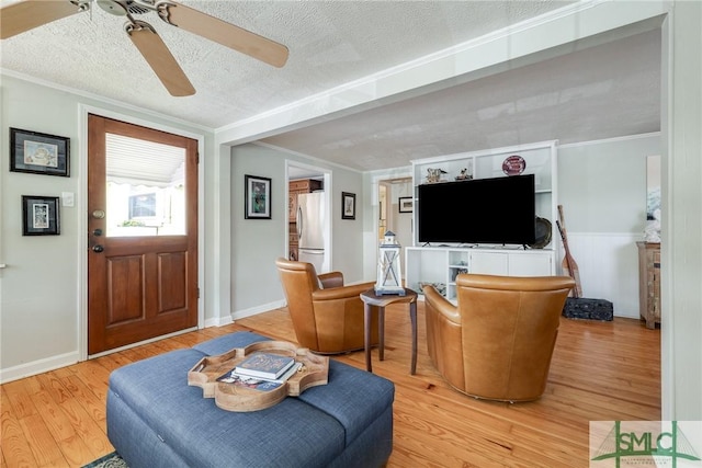 115 2nd Ave, Tybee Island, GA 31328 - living room featuring ceiling fan, light wood finished floors, a textured ceiling, and crown molding