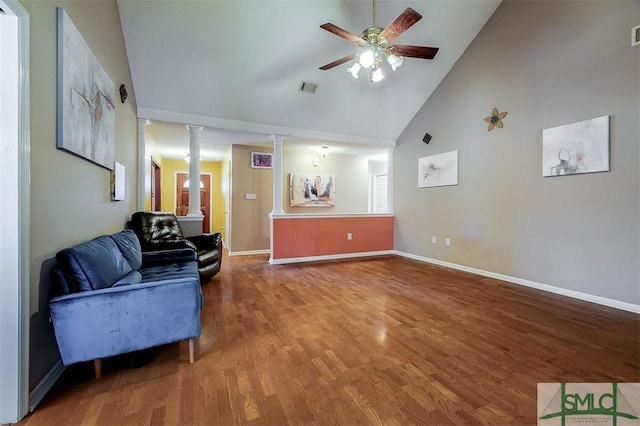 living room with ceiling fan, wood-type flooring, high vaulted ceiling, and ornate columns