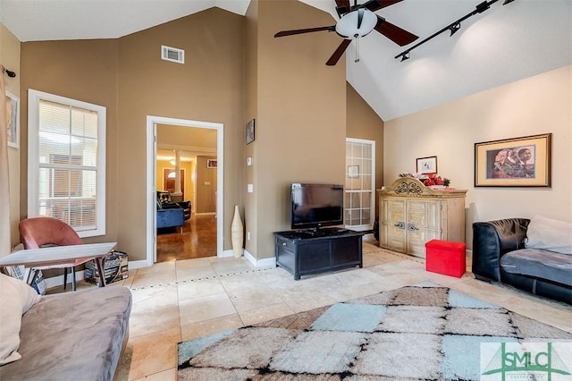 tiled living room featuring ceiling fan, rail lighting, and high vaulted ceiling