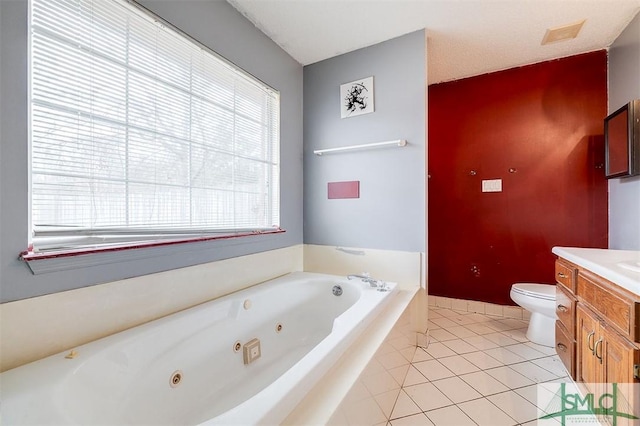 bathroom featuring tile patterned flooring, vanity, a tub to relax in, and toilet