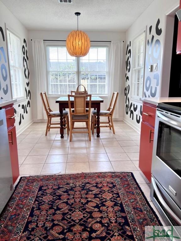 tiled dining space with a textured ceiling