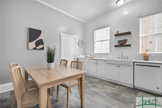 dining space featuring sink, ornamental molding, and brick wall