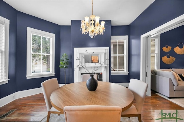 dining area with wood-type flooring and a chandelier