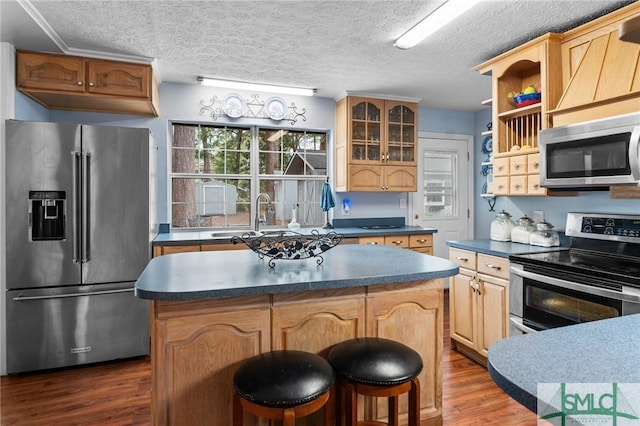 kitchen with sink, stainless steel appliances, dark hardwood / wood-style floors, a center island, and a textured ceiling