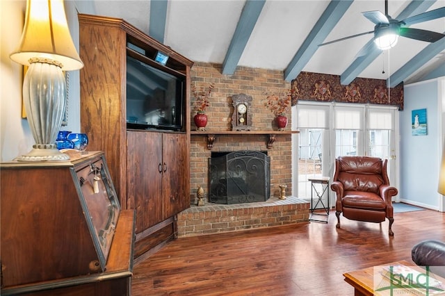 living room featuring beamed ceiling, ceiling fan, a brick fireplace, and dark hardwood / wood-style flooring