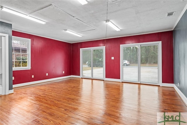 spare room featuring hardwood / wood-style flooring and ornamental molding