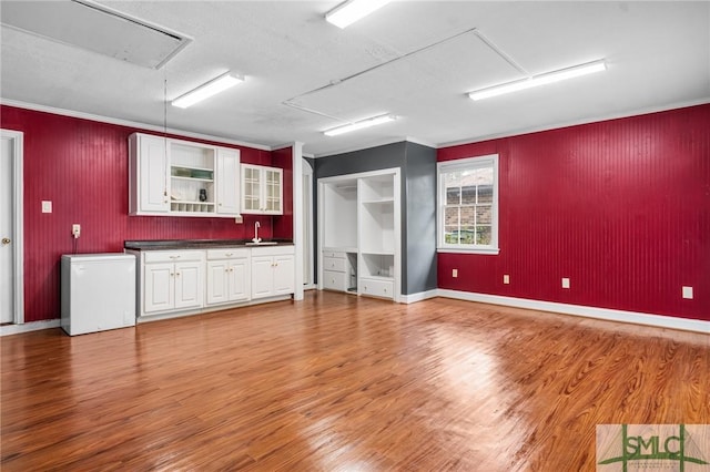 unfurnished room featuring crown molding, sink, and hardwood / wood-style floors